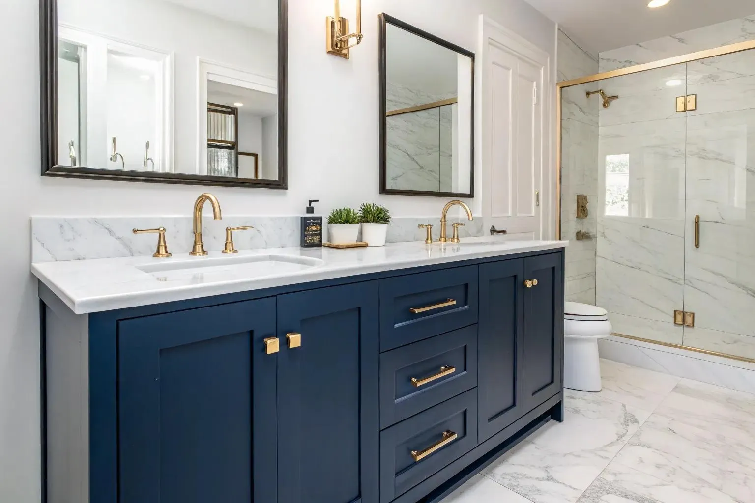 Navy double vanity with drawers, brass hardware and a white marble countertop